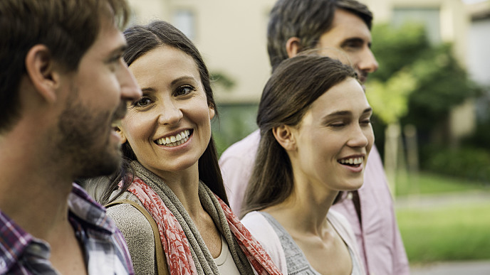 Mulher com dentes brancos sorrindo com amigos