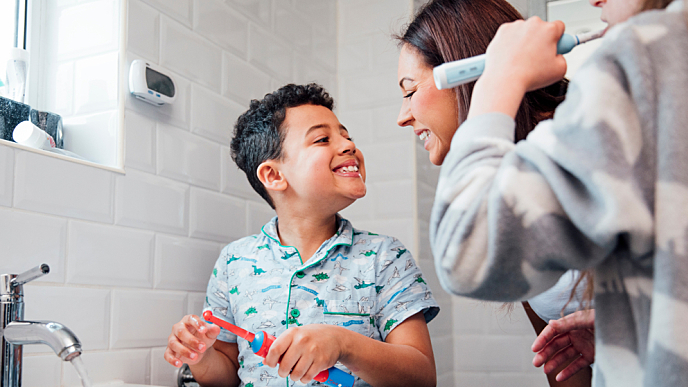 Família usando escova elétrica dental 