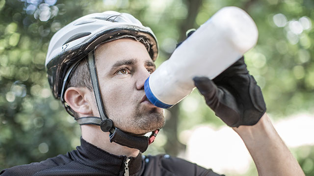 homem bebendo água para ficar hidratado durante passeio bicicleta