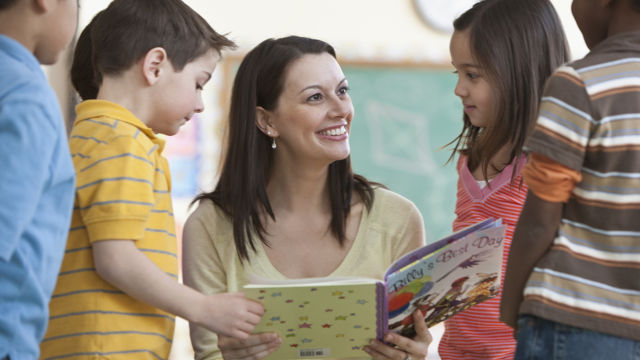 Profesora lendo livros para seus alunos