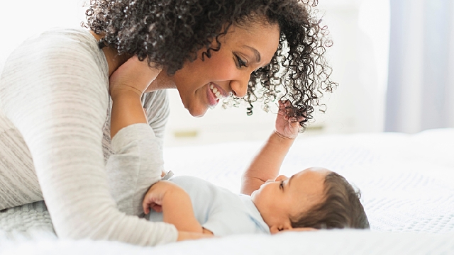 Mãe e filho sorrindo na cama