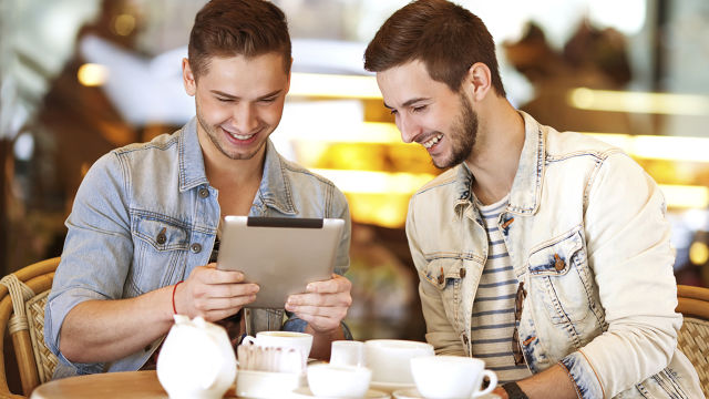 Dois homens sorrindo na cafeteira