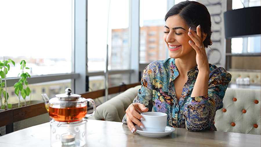 Mulher sorridente tomando café em uma cafeteria