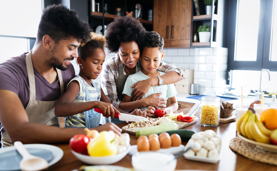 Família feliz na cozinha, se divertindo e cozinhando Comida saudável