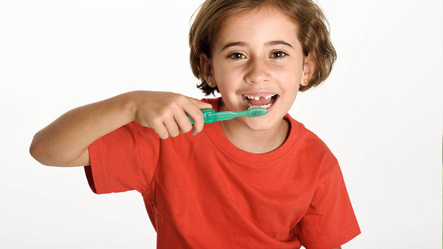 menina feliz escovando seus dentes