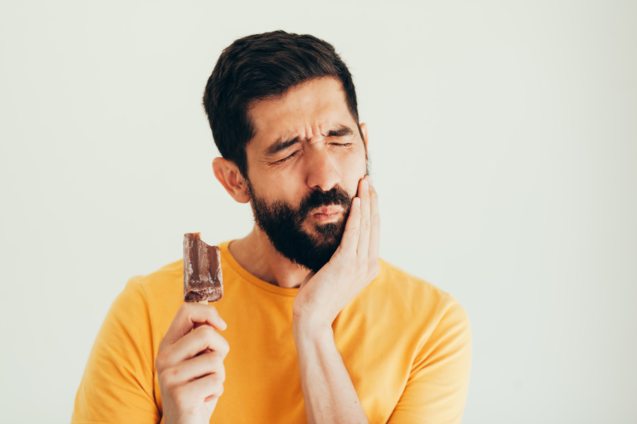 homem com dentes sensíveis depois de comer gelado