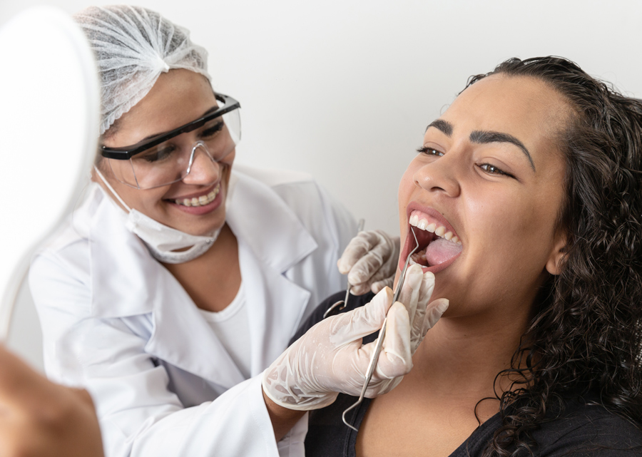 Paciente mostrando boca durante exame feito pelo dentista