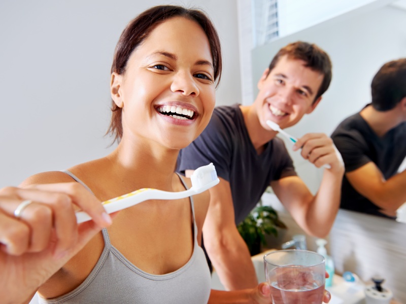 Casal escovando os dentes para remover a placa bacteriana