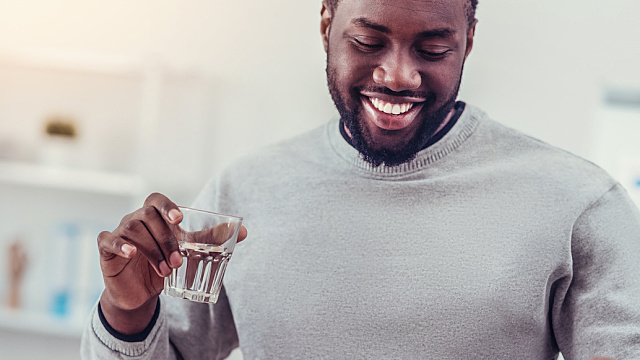 Homem tomando medicamentos genéricos