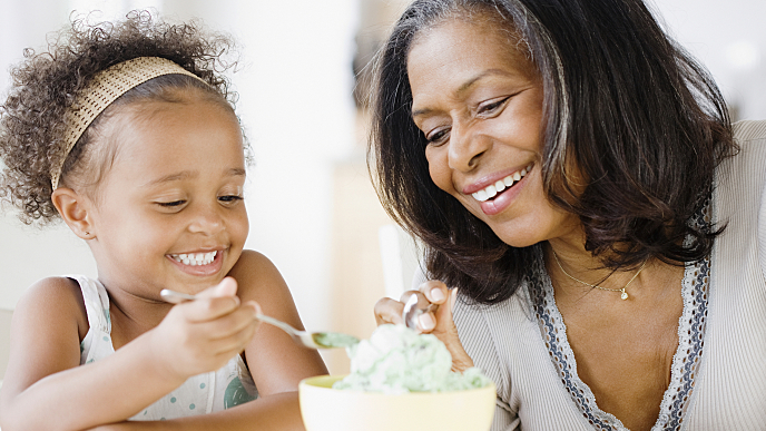 Mãe e filha sorrindo e compartilhando juntas um gelato