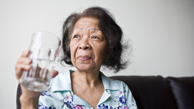 mulher com boca seca tomando água