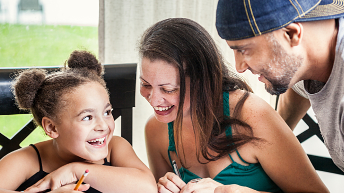 mãe, pai e filha fazendo um trabalho de escola