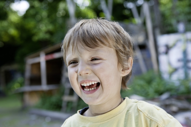 Menino brincando no parquinho e sorrindo